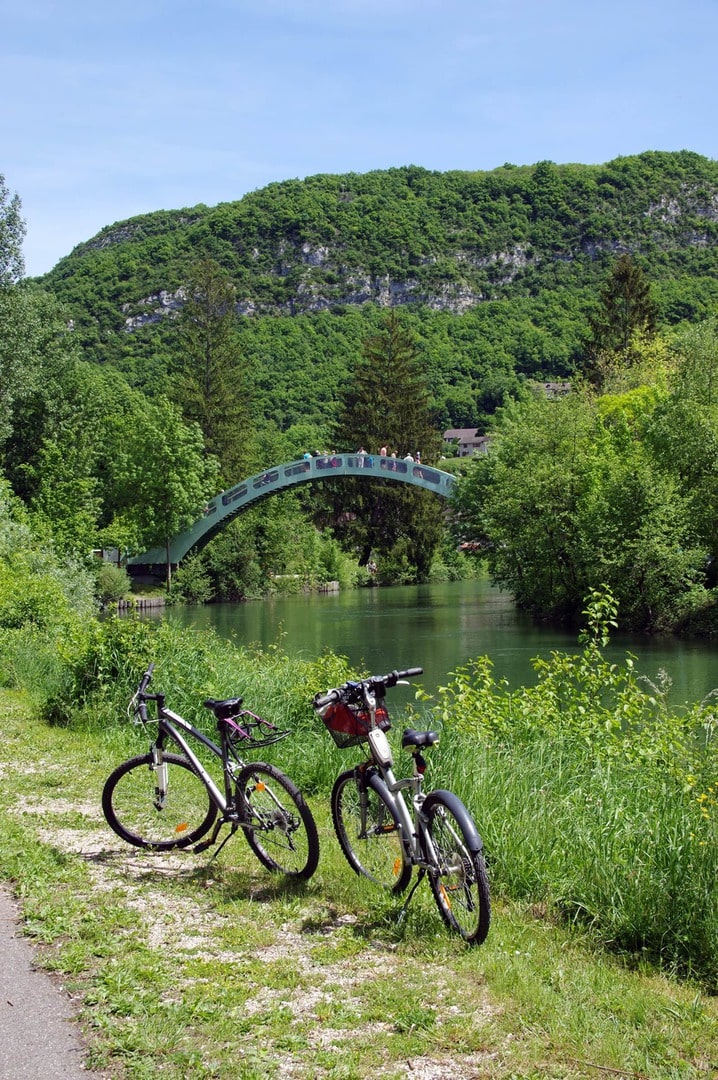 Radreise Schweiz Frankreich Rhoneradweg - Fahrräder mit Blick auf kleine Brücke über Fluss